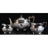 Property of a lady - an early 20th century silver three-piece tea-set, with repousse 'C'-scrolls &