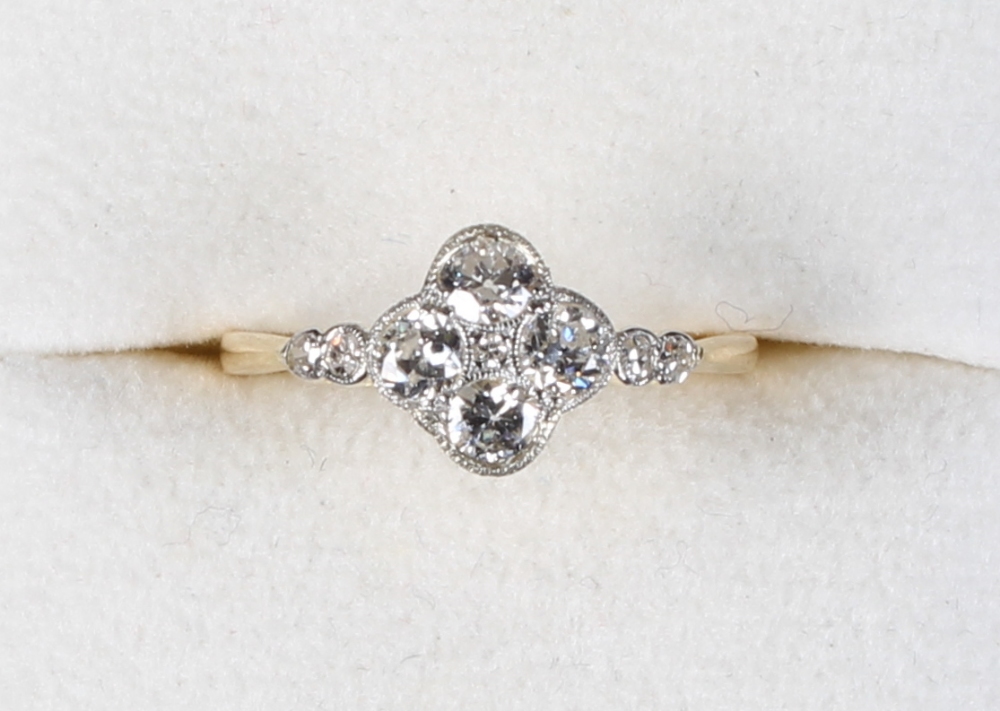 An unmarked yellow gold diamond cluster ring, with quatrefoil millegrain setting, the estimated