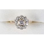 A yellow gold diamond cluster ring, with collet set central brilliant cut diamond flanked by 10