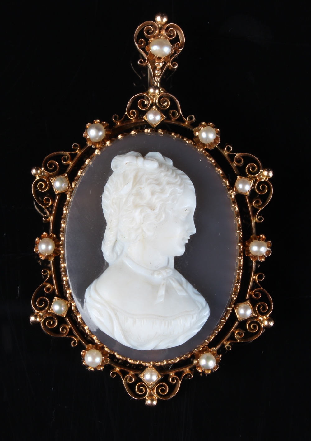 A well carved French oval shell cameo pendant brooch, the openwork frame set with pearls, the pin