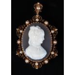 A well carved French oval shell cameo pendant brooch, the openwork frame set with pearls, the pin