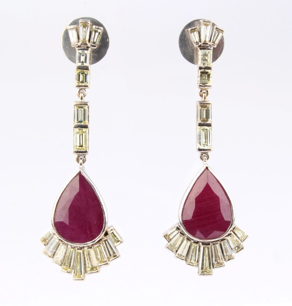 A pair of ruby & diamond pendant earrings, each with seven baguette cut diamonds above a large