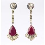 A pair of ruby & diamond pendant earrings, each with seven baguette cut diamonds above a large