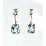 A pair of white gold aquamarine & diamond pendant earrings, each with a rectangular cut aquamarine