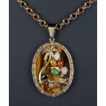 Property of a deceased estate - a Chinese yellow metal mounted tiger's eye oval pendant set with