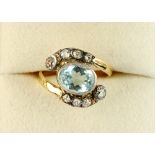 An unmarked yellow gold aquamarine & diamond ring, the oval cut aquamarine weighing an estimated 1.3