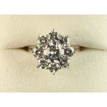 An 18ct white gold diamond cluster ring, the central brilliant cut diamond weighing approximately