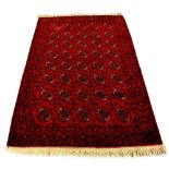 A Lori woollen hand-made rug with red ground, 100 by 62ins. (253 by 158cms.) (see illustration).