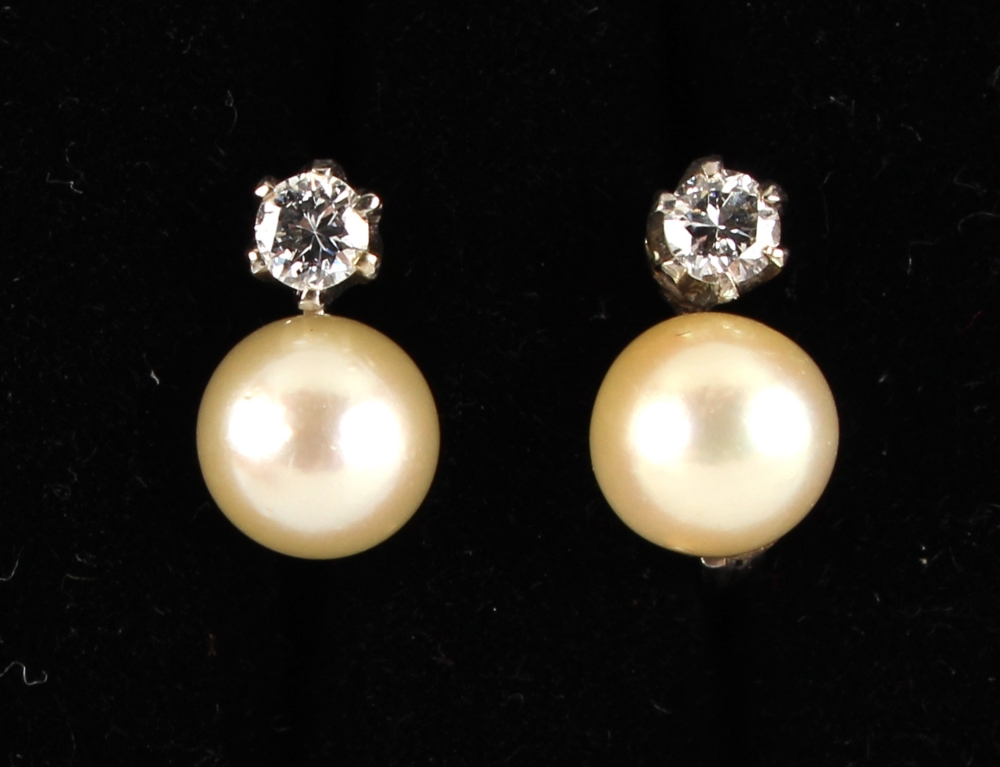 A pair of pearl & diamond earrings, each with a single pearl set below a single round brilliant