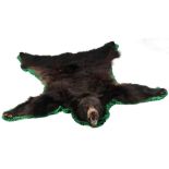 Property of a lady of title - a taxidermy black bear skin rug, with stuffed head & claws, label