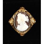 A Victorian unmarked yellow gold oval shell cameo brooch, with scroll & foliate decorations, 1.6ins.