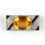 An Art Deco black enamel & diamond rectangular brooch, set with a large oval cut citrine, the frieze