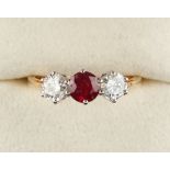 An 18ct yellow gold ruby & diamond three stone ring, the round cut ruby approximately 0.50 carat,