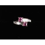 An 18ct white gold pink sapphire & diamond ring, the crossover setting with two square cut pink