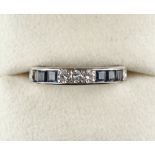 A white gold or platinum sapphire & diamond eternity ring, set with rows of three round brilliant