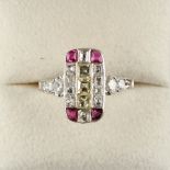 A Continental white gold or platinum ruby & diamond ring, the rectangular setting with a row of