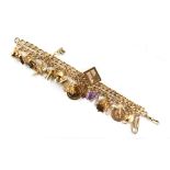 Property of a lady - a 9ct gold charm bracelet, formed from a watch chain, with twenty-one charms,