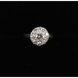 An 18ct white gold diamond cluster ring, the central brilliant cut diamond approximately 0.6