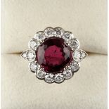 A white gold rubelite & diamond cluster ring, the round cut rubelite weighing approximately 5.90