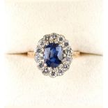 A good yellow gold sapphire & diamond cluster ring, the vivid blue oval cut sapphire weighing