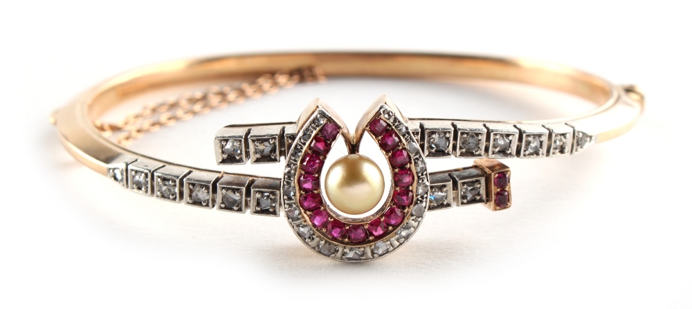 An early 20th century yellow gold ruby & diamond horseshoe bracelet, set with an untested pearl,