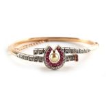 An early 20th century yellow gold ruby & diamond horseshoe bracelet, set with an untested pearl,