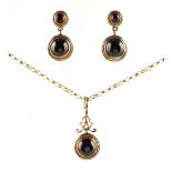 A yellow gold cabochon garnet pendant on 9ct yellow gold chain necklace, the chain 15ins. (38cms.)