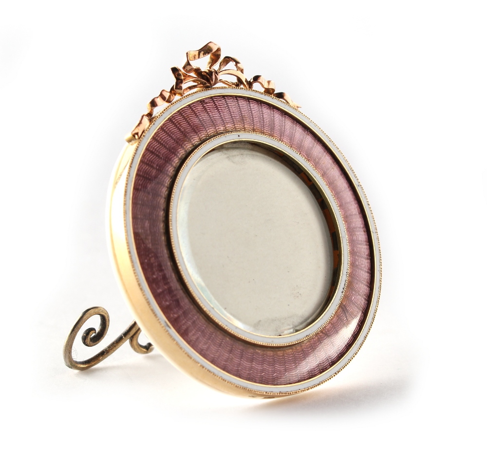 A small Faberge 14ct gold & pink guilloche enamel circular easel photograph frame, with ribbon