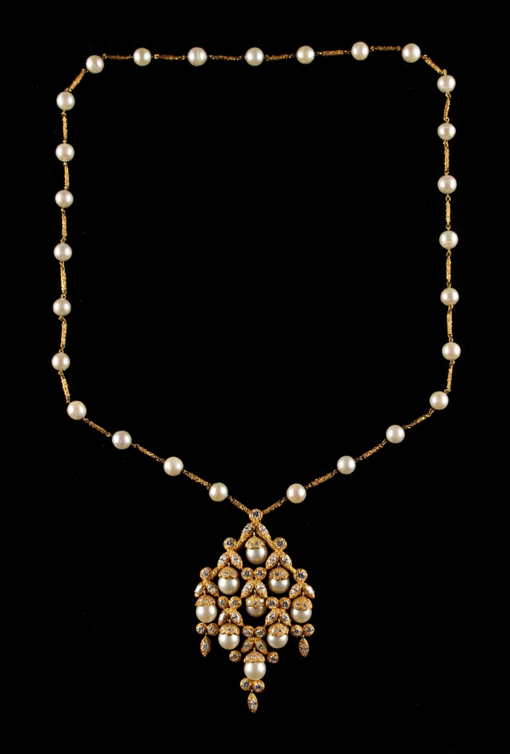 A modern 18ct yellow gold pearl & diamond pendant necklace, with textured bark setting, the