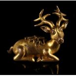 A Chinese gilt bronze scroll weight modelled as a recumbent deer, 2.55ins. (6.5cms.) high (see