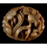 A Chinese russet jade carving modelled as an oval ring with birds among lotus, 3.6ins. (9.1cms.)