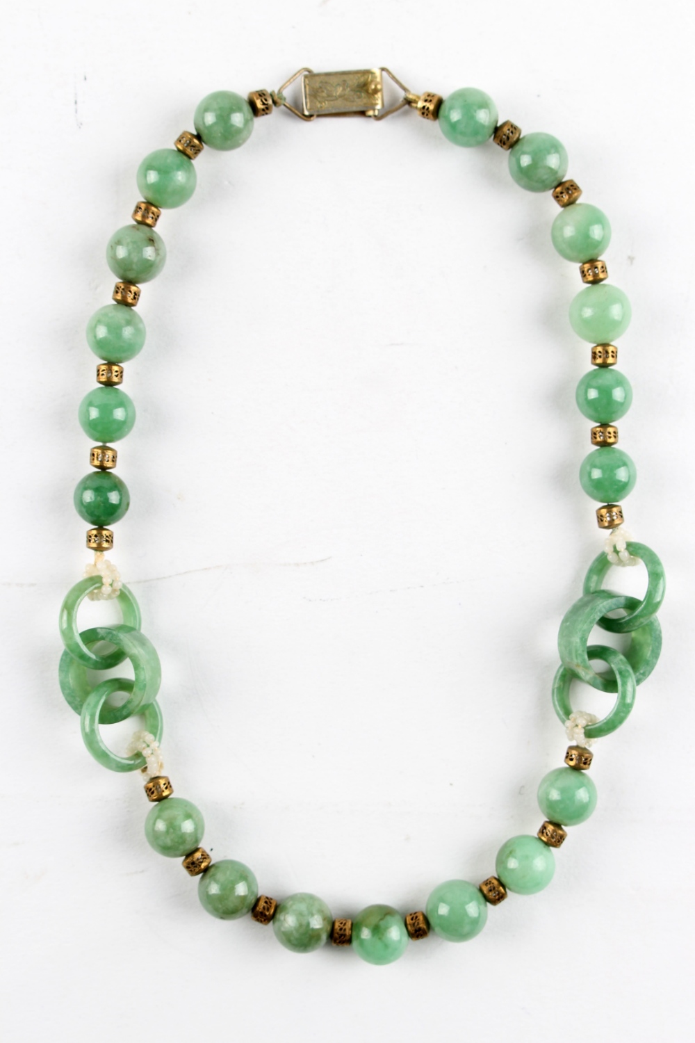 A Chinese jadeite bead & triple ring necklace, with gilt metal spacers, 16.5ins. (42cms.) long (