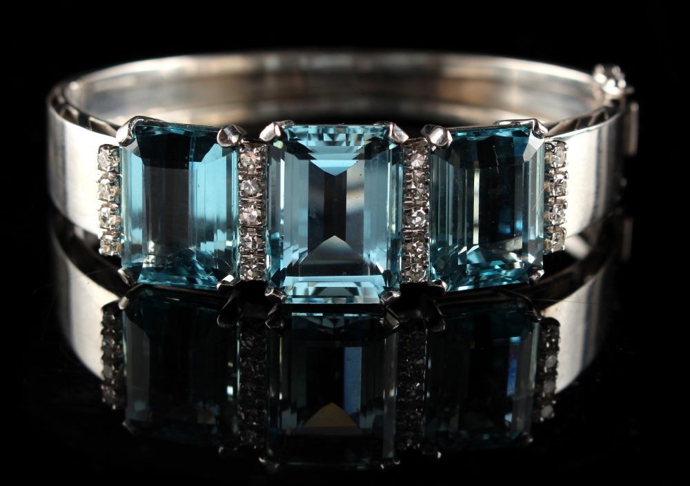 A good French white gold hinged bracelet set with three large aquamarines bordered by rows of