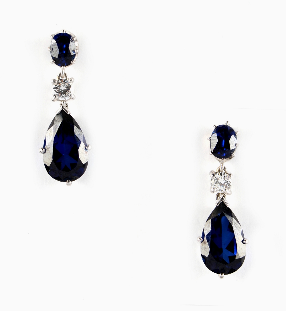 A pair of blue 'stone' & diamond pendant earrings, each with a pear shaped & an oval shaped blue '