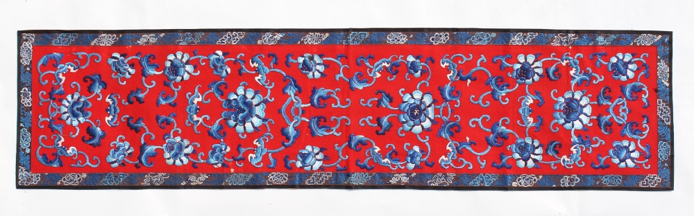 A Chinese embroidered silk panel decorated with bats & flowers on a bright red ground, early 20th