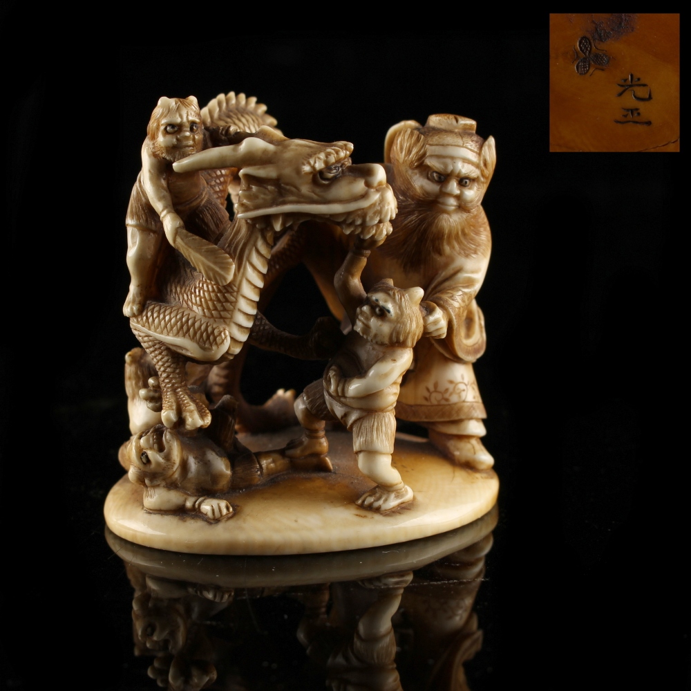 Property of a gentleman - a Japanese carved ivory okimono depicting a dragon & oni, Meiji period (