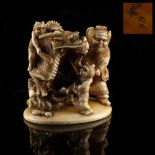 Property of a gentleman - a Japanese carved ivory okimono depicting a dragon & oni, Meiji period (