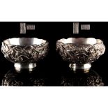 A pair of late 19th / early 20th century Japanese silver bowls, with repousse dragon decorations &