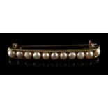 An early 20th century unmarked high carat yellow gold & pearl bar brooch, 1.8ins. (4.6cms.) long (