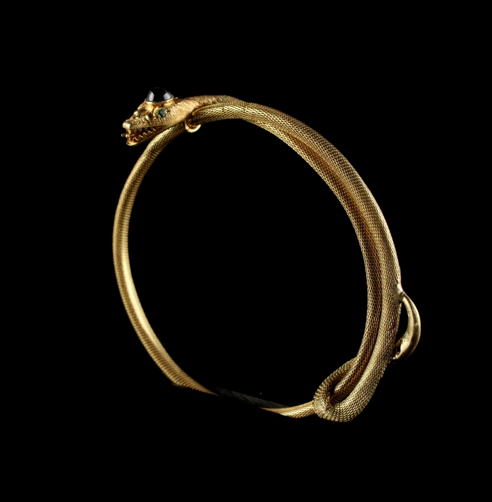 An 18ct yellow gold snake bracelet, the head with cabochon blue 'stone' & green 'stone' eyes,