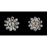 A pair of unmarked white gold diamond flowerhead earrings, each with a central diamond within ten