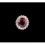 A 9ct yellow gold pink tourmaline & diamond cluster ring, the oval cut tourmaline approximately 2.93