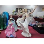 A Pair of German Porcelain Figurines of Ladies, in flowing movement, each on oval base, height