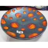 Large Poole Pottery Charger, decorated with stylised oranges on black lustre ground 41 cms diameter.