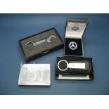 Four Mercedes Benz Branded Items, including a combined cigarette holder and lighter and an enamel