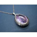 A Modern 18ct White Gold Pear Shape Amethyst and Diamond Set Pendant, four claw set, within