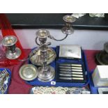 An Electroplated Three Branch Candelabra, cigarette box, cased set of six tea knives, dish, napkin