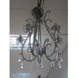 A Modern Chrome Effect Five Scroll Branch Chandelier, fitted with facetted glass teardrops- and