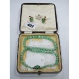 A Polished Green Hardstone Bead Necklace, of graduated design to oval collet set clasp, indistinctly