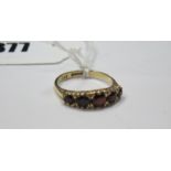 A 9ct Gold Garnet Set Ring, of graduated design in scroll carved setting.